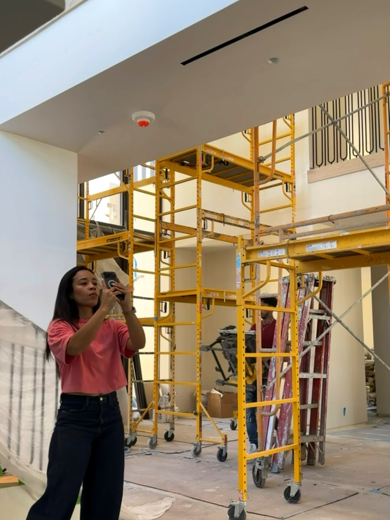 Grabación en una obra en construcción, entre andamios, con el equipo trabajando al fondo